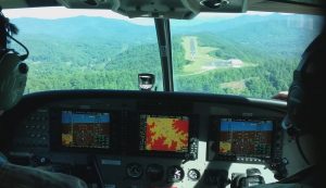 A view from the cockpit as the aircraft approaches a mountain landing strip